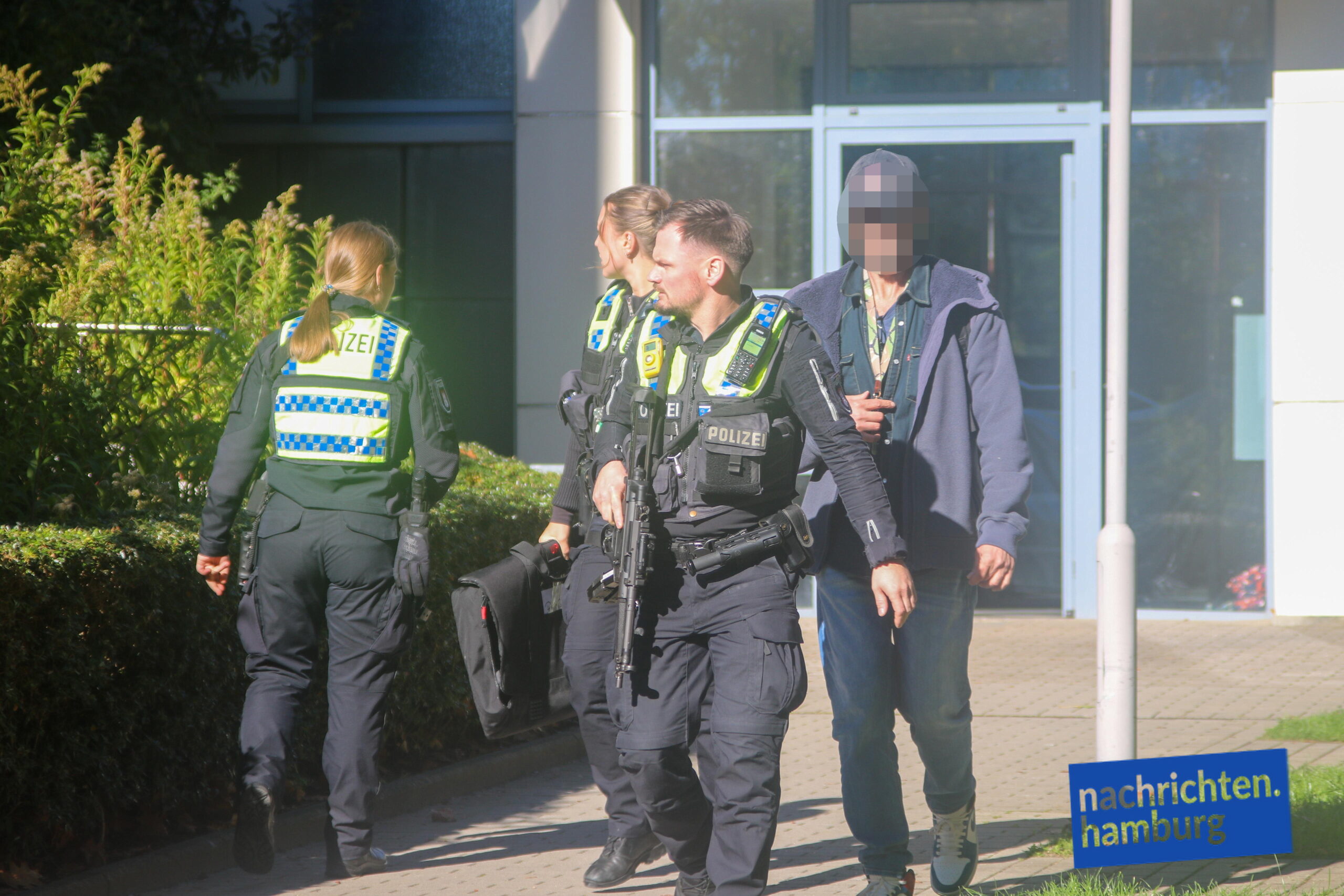 Schwer bewaffnete Polizisten kommen aus dem Haus in der Korachstraße